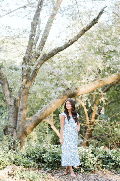 a young lady standing in front of spring blooms at The Tuscaloosa Arboretum