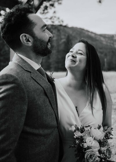 Maddie Rae Photography black and white of bride and groom. she is looking up at him  smiling and he is looking off in the distance