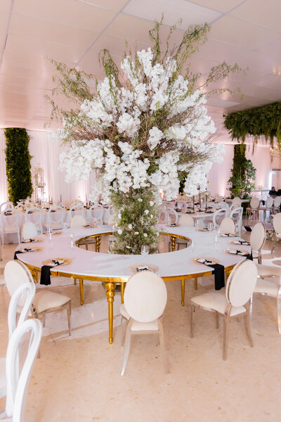 Una boda de lujo para no olvidar, con una mesa de invitados y un arreglo grande en el centro.