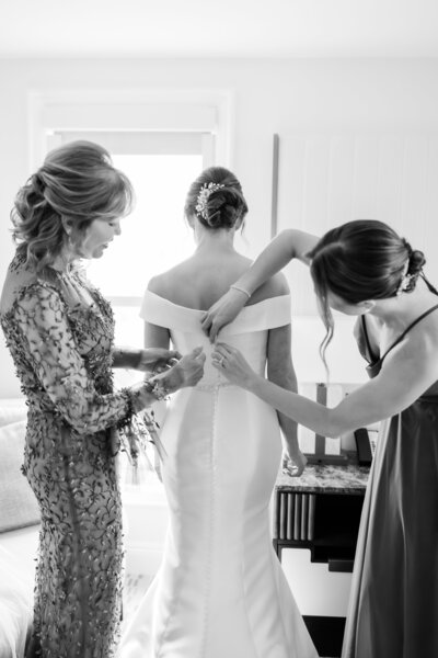 A bride getting ready at the Ritz Carlton Orlando in a black and white photo showing off the back of her gown by Florida wedding photographer Angelika Krug Photo & Film