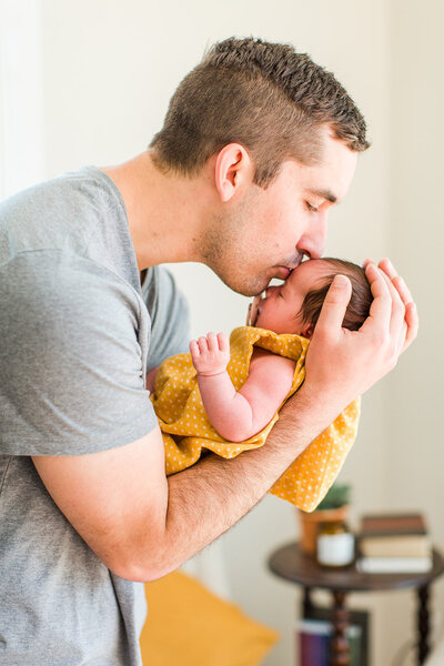 father kisses baby on the head
