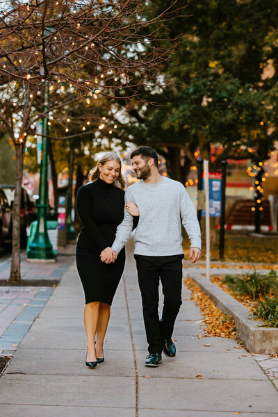 Engagement couple walking down city