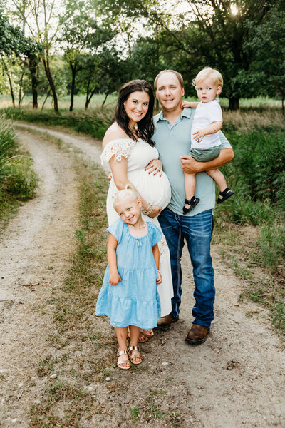 Family posing around pregnant mother for a picture near St. Paul, Ne.