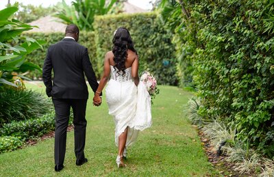 Bride and Groom walking hand in hand on grass at Destination Wedding at The Palms Hotel in Miami, FL