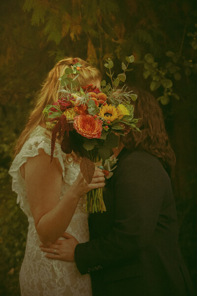 Man and woman romantically spin around, laughing in the middle of a  flowery field
