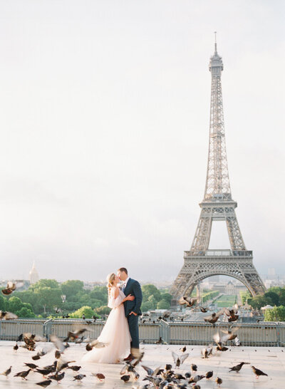 Couple Kissing with Birds Flying at Eiffel Tower in Paris France Photo