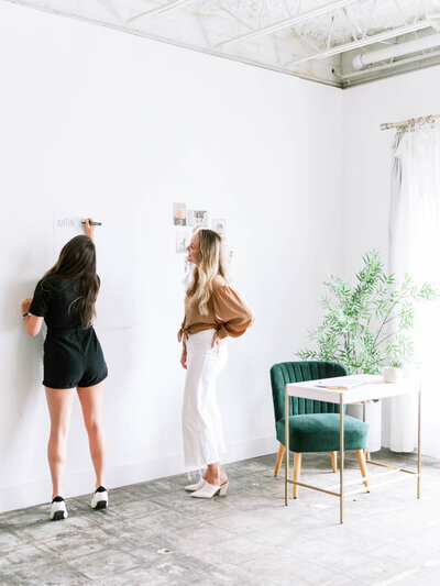 two women standing together creating a marketing strategy for boutique hotels, airbnb and hospitality groups with high level marketing and ad strategies.