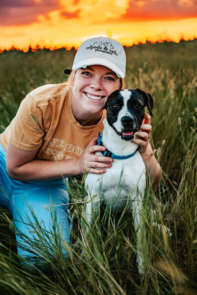 girl hugs dog in Nebraska field of grass