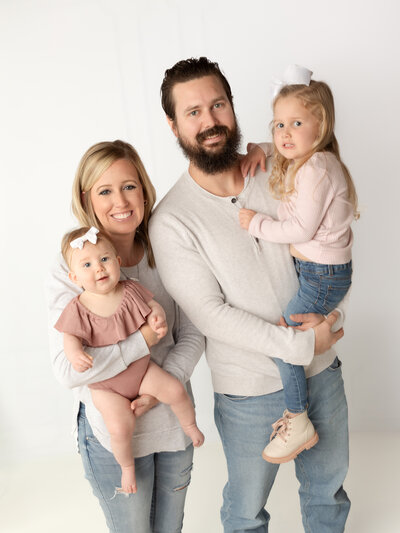mom and dad holding two daughters for studio family portraits cleveland family photographer