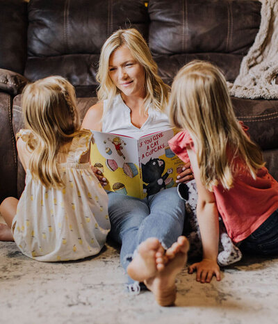 mother and children reading on floor