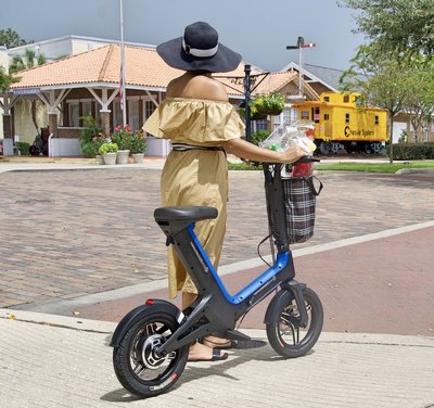 Lady strolling with Blue Go-Bike M3 wearing hat as she leaves the market with her groceries