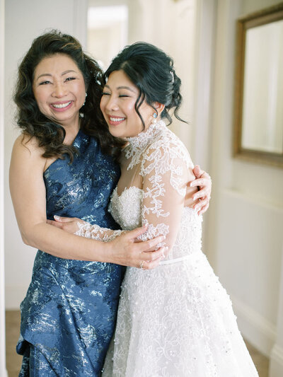 bride hugging mother and smiling