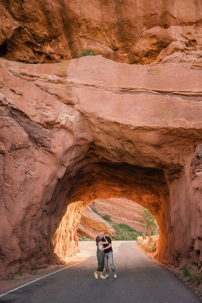 Couple kissing at Red Rocks Park in Colorado after their proposal and engagement