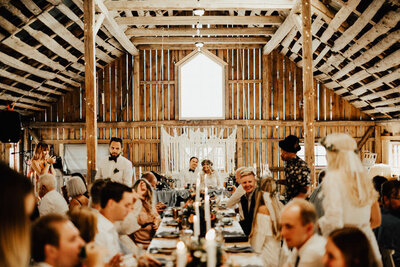 brudpar och långbord med alla gäster i bohemisk loge under bröllop på bergs gård i trosa