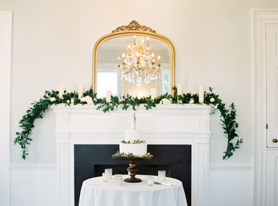 Gadsden House Wedding  Cake and Fire Place Mantle with Gold Mirror Greenery Garland Pillar Candles