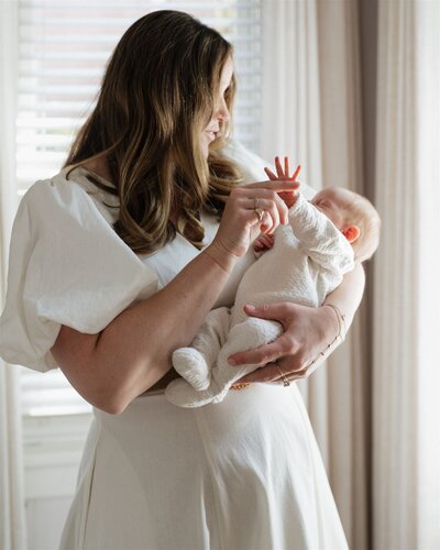 Family portrait with two young daughters in dresses, parents embracing them