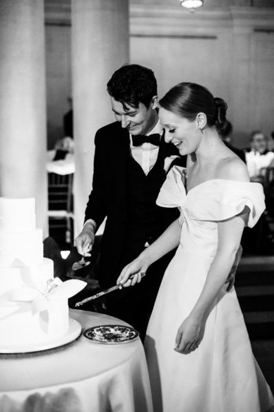 bride and groom cutting a wedding cake at their frick museum collection wedding
