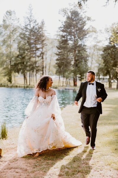 An image of newlyweds walking along a lake while laughing captured by a Cannon Beach Wedding Photographer