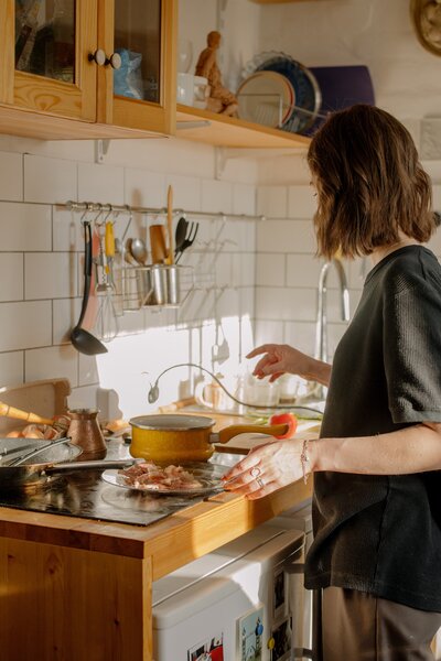 Menopausal Woman cooking in a cosy kitchen to help with her symtpoms