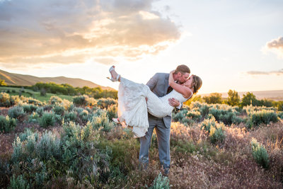 Bride and groom in passionate kiss at sunset in field in New Mexico