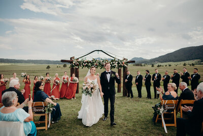 Couple walking down the aisle at an outdoor colorado wedding venue spruce mountain ranch