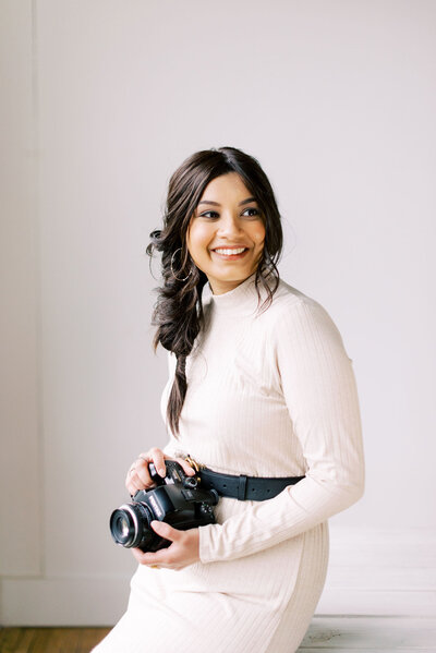 a portrait of Sara Abdulaziz holding a film camera