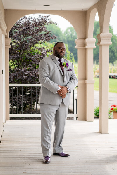 Stylish groom posing in gray suit at upstate New York wedding, photographed by wedding photographer Niko Coric - Lumen Clarity Media