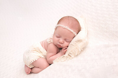 baby girl on cream pillow in newborn photography near  hillsboro oregon