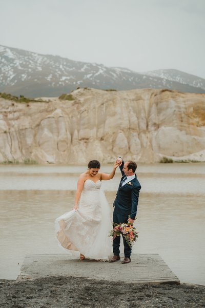 bride ad groom dancing on the banks of Saint Bathans lake