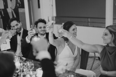 Bride, Groom and guests raising glasses at wedding reception at Mass MoCa