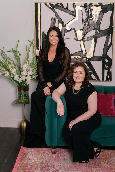 Two medspa doctors sitting together on a green couch