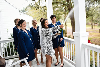 Bride and bridesmaids celebrate with champagne at  The Venue at Southern Oaks, Mississippi  Wedding