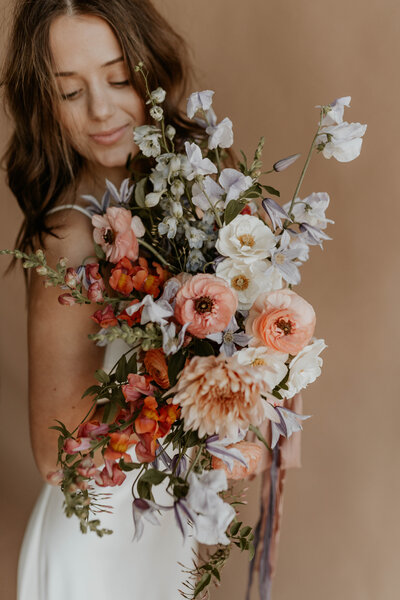 woman fixing brides bouquet of flowers
