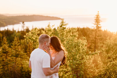 engaged couple kissing at sunrise