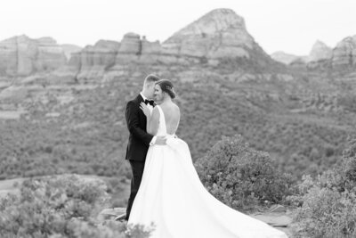 A bride and groom share an intimate embrace overlooking a mountainous landscape, embodying the elegance of destination weddings planned by Socially Significant Events.