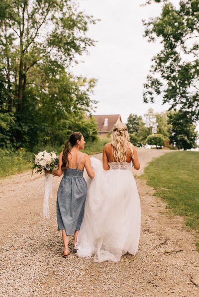 Bride walking with her Maid of Honor down a path