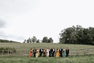 Bridal party standing in field in front of fence, UME (New England Event Planners) helped with wedding