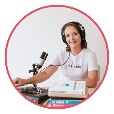 Image of Emily May at her Podcasting desk wearing headphones