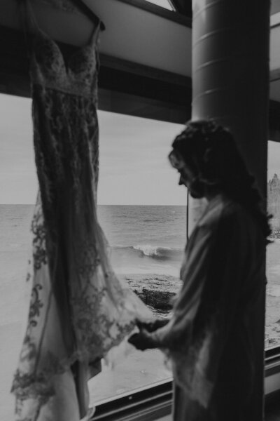 Bride looking at her wedding dress with Lake Superior in the background at Bluefin Bay in Tofte MN