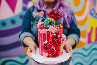 Bunniecakes Bakery in Miami Girl with Purple Hair Holding Colorful Cake