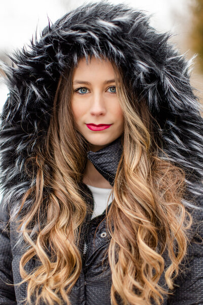 Senior girl snow session with fur hood and long curly hair
