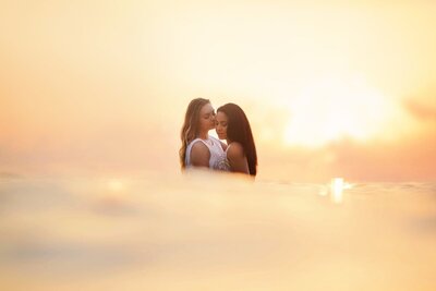 couple wearing white holds one another close during their romantic Maui engagement photoshoot