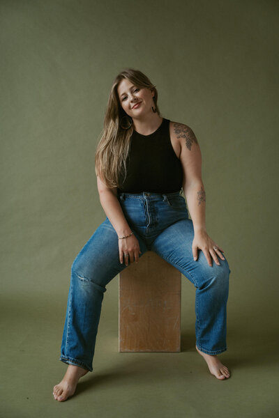 woman sitting on a box while smiling