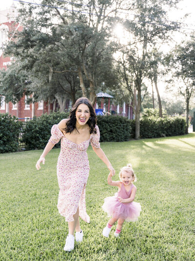 mother and daughter holding hands while wearing pink dresses