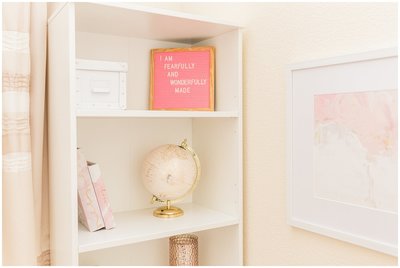 white bookshelf with pink letterboard and pink globe