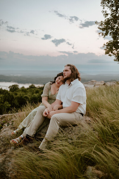 couple sitting in field and looking off into the distance