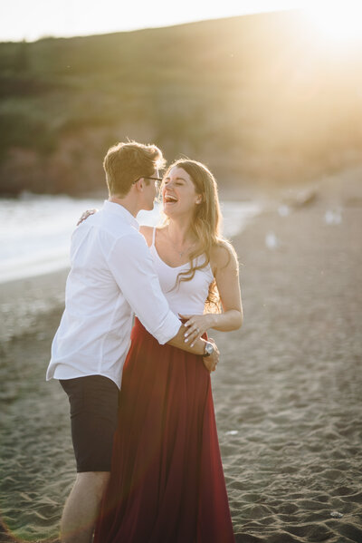 A couple standing on the beach with the sea in the background taken by Cornwall Wedding Photographer and Devon Wedding Photographer Liberty Pearl