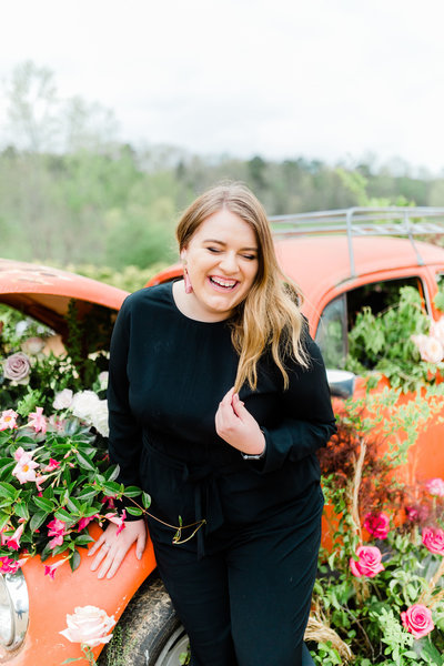 PICTURE OF KAYLEE CREIGHTON STANDING IN FRONT OF CAR FULL OF FLOWERS