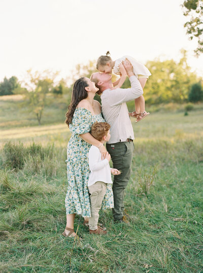 photo of family in a grassy green field in summer, taken by Madison WI photographer Talia Laird Photography