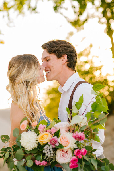Jackson Hole photographers capture bride and groom leaning into kiss during vibrant outdoor portraits
